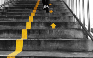 Image of a person running up stairs with painted arrows