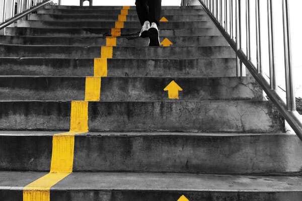 Image of a person running up stairs with painted arrows