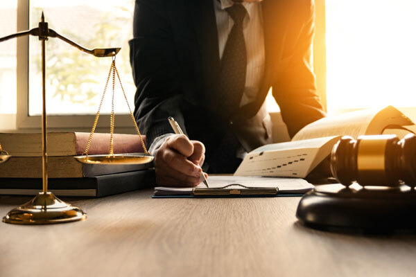 Image of a man signing a document in a law firm